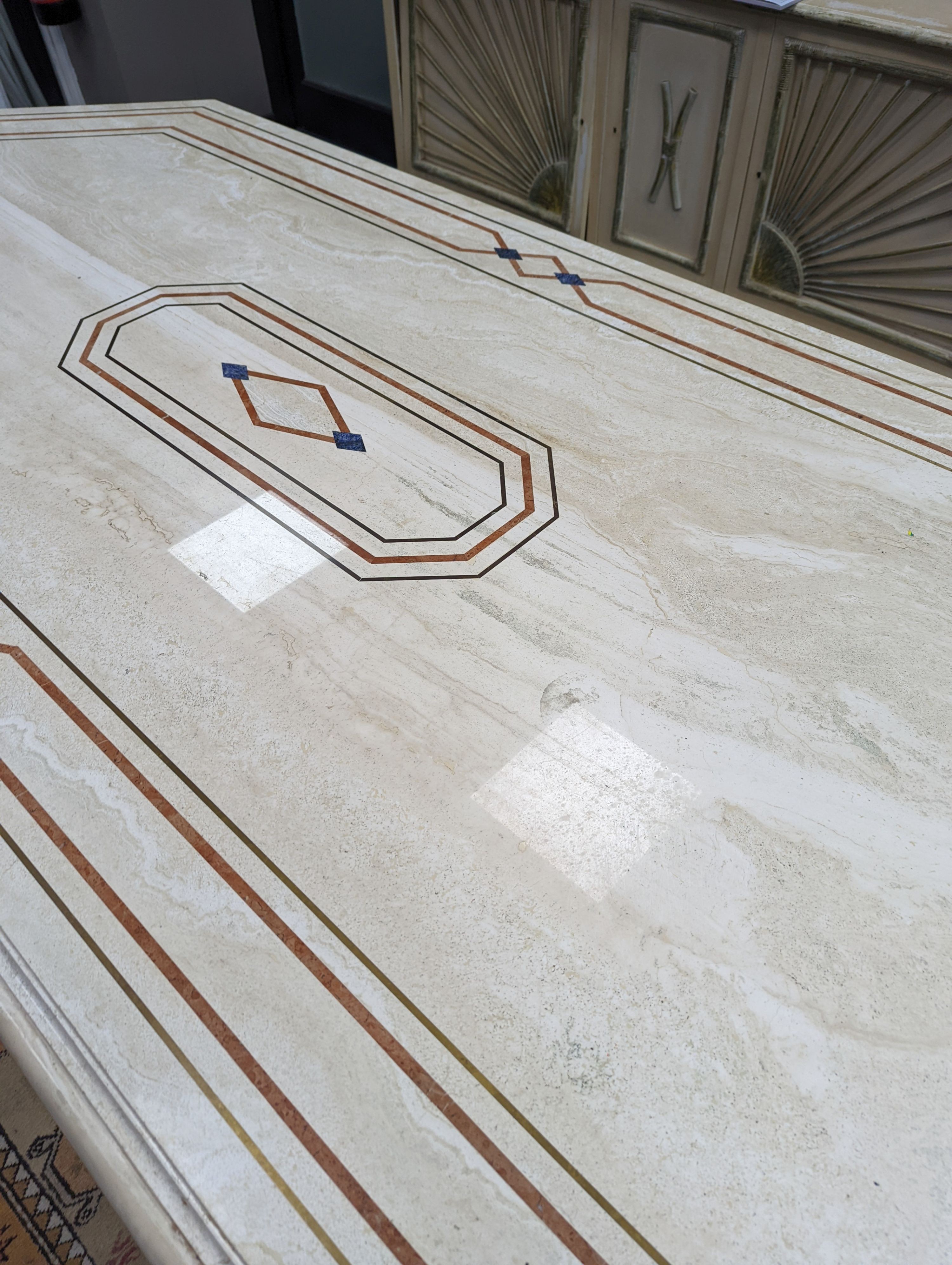 A Travertine marble dining table of elongated ocgtagonal form on twin octagonal column supports, length 260cm, depth 120cm, height 74cm